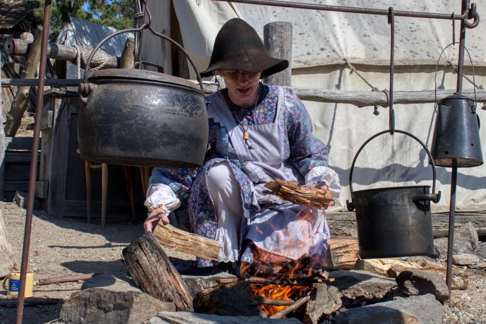 Woman burning logs in a fire