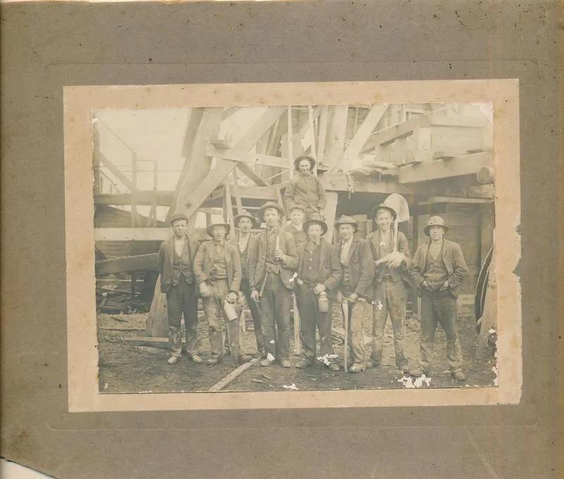 Historic photograph of a group of gold miners posing beside mining machinery, from Australia’s most visited outdoor museum and heritage attraction.