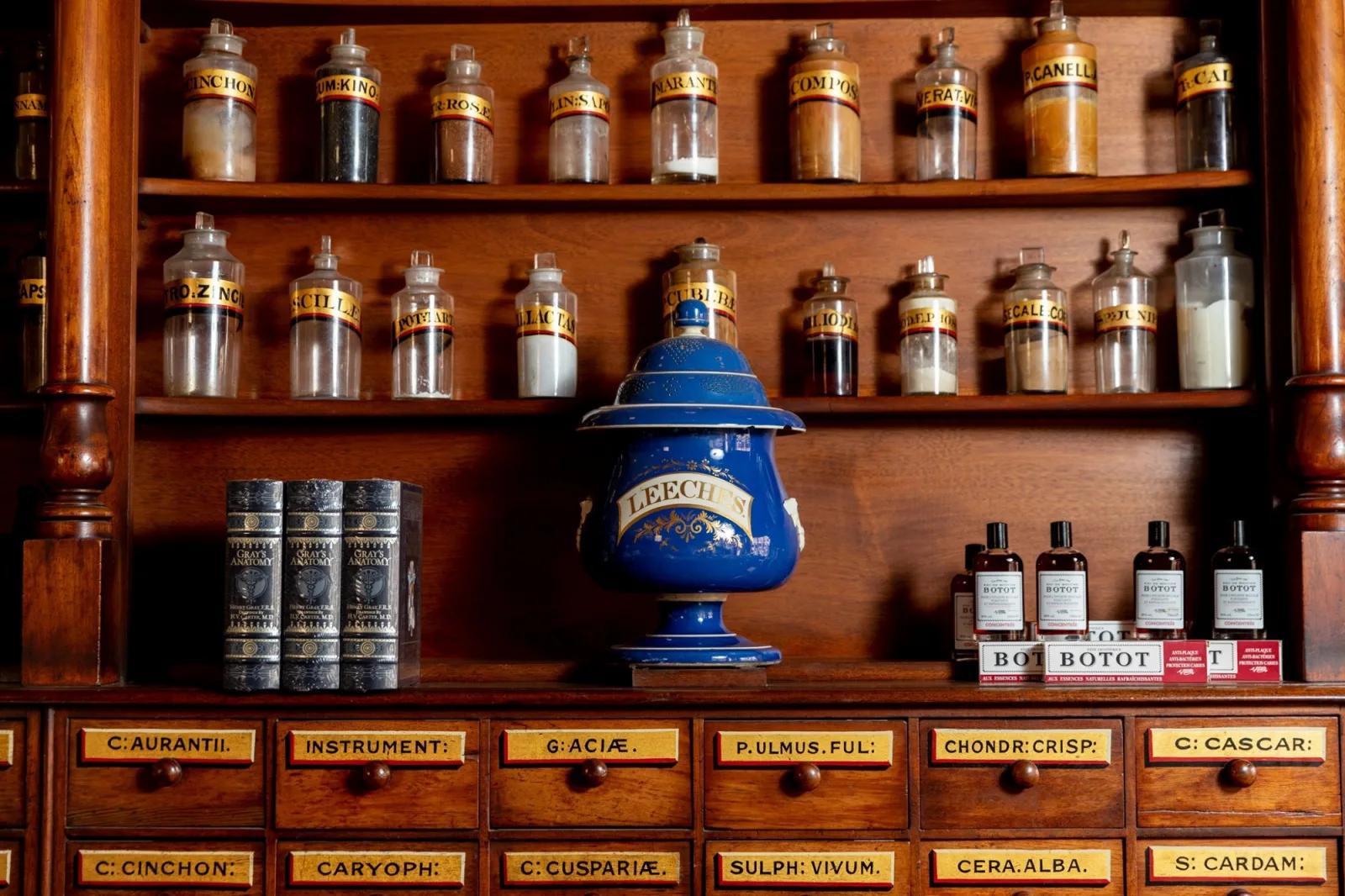 Heritage apothecary with vintage medicine bottles, labeled drawers, and a traditional blue leech jar, from Australia’s most visited outdoor museum and heritage attraction.